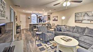 A spacious living room with a grey sofa, patterned armchair, and a coffee table. A ceiling fan and recessed lighting are visible. - 4 Mi to Strip: Cozy Lake-View Retreat in Branson (Branson)