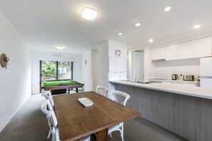 A modern kitchen with white cabinets, a built-in oven, and a sink.