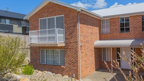 A two-story brick house with a balcony, a garage, and a covered porch. - Oberlaken - 2/125 Gippsland Street (Jindabyne)