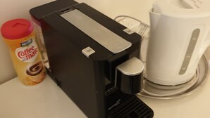 Una cafetera y un dispensador de cápsulas de café sobre una encimera blanca.