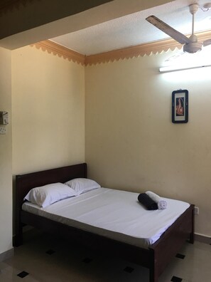 Cozy retreat with a comfortable bed, ceiling fan, and framed artwork.
