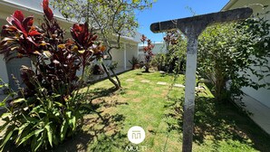 A well-maintained garden with a variety of plants and a pergola structure. - Encanto na Praia da Daniela \- Florianópolis \- SC (Florianópolis)