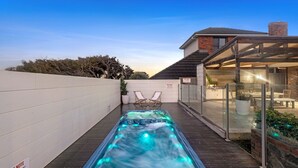 A hot tub on a wooden deck with a glass enclosure, a white wall, and a sign indicating pool rules. - 10 Ocean Drive - one of those properties that  will have you never wanting to leave (Port Fairy)
