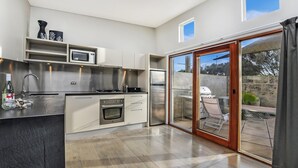 A modern kitchen with a built-in oven, microwave, and stainless steel appliances. - Hearns Beachside Villa 1 (Port Fairy)