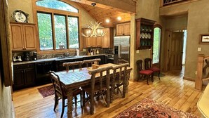A spacious kitchen with wooden cabinets, a large island, and a chandelier. - Hidden Hollow 2 BR 2 baths WALK to town (Highlands)