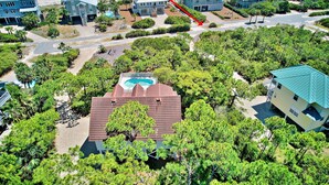Una vista aerea di una zona residenziale costiera con case, una piscina e una spiaggia.