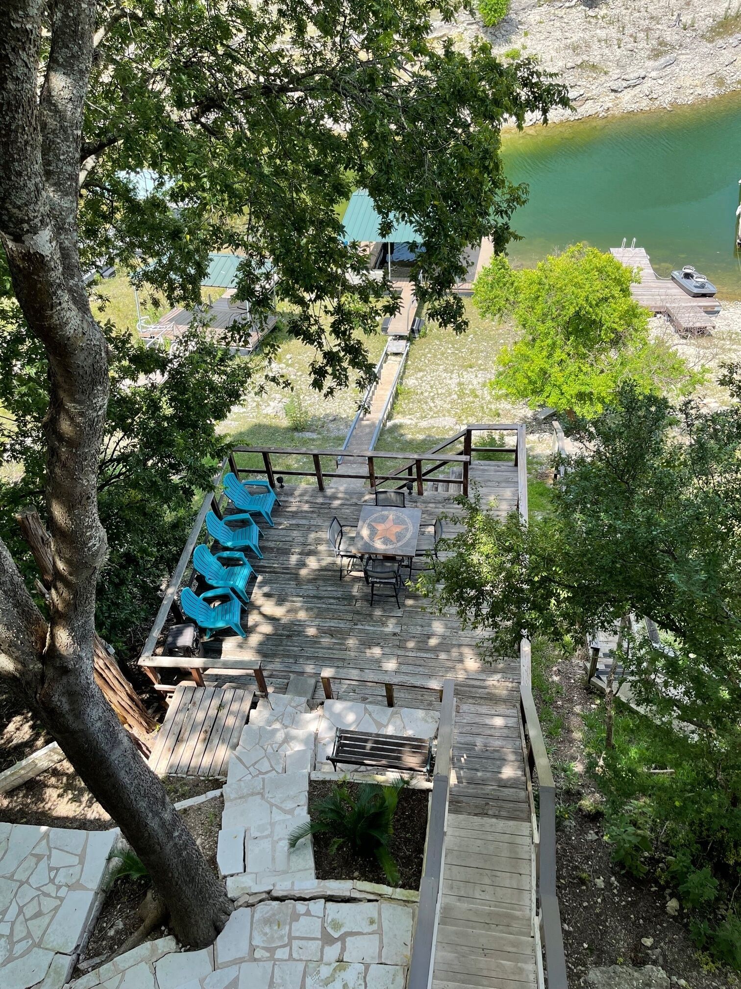 Una terraza de madera con mobiliario exterior y vista a un lago.