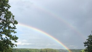 A grassy area with a view of a lake and a rainbow. - Beautiful family retreat (Wayne)