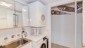 A modern bathroom with a built-in washing machine, a sink, and a shower area. - Central Park - 10/1 Snowy River Avenue (Jindabyne)