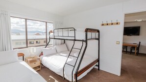 A bunk bed room with a view of buildings and mountains through the window. - Central Park - 10/1 Snowy River Avenue (Jindabyne)