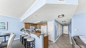 Una cocina moderna con una isla central, taburetes de bar y armarios de madera.