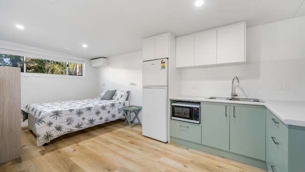 A compact room with a bed, a small table, a refrigerator, a microwave, and a sink. - Off The Wall - close to beach, river and breakwall (NORTH HAVEN)