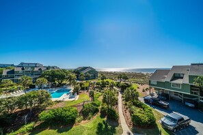 A residential area with houses, a swimming pool, and a view of the ocean. - Mariners Walk 10E in Wild Dunes- Ocean front 3 bedroom villa Isle of Palms with community pool. (Isle of Palms)