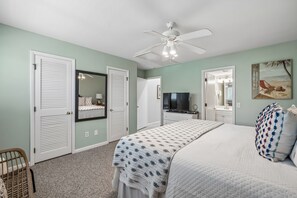 A bedroom with a bed, a ceiling fan, a TV, and a painting on the wall. - Mariners Walk 10E in Wild Dunes- Ocean front 3 bedroom villa Isle of Palms with community pool. (Isle of Palms)