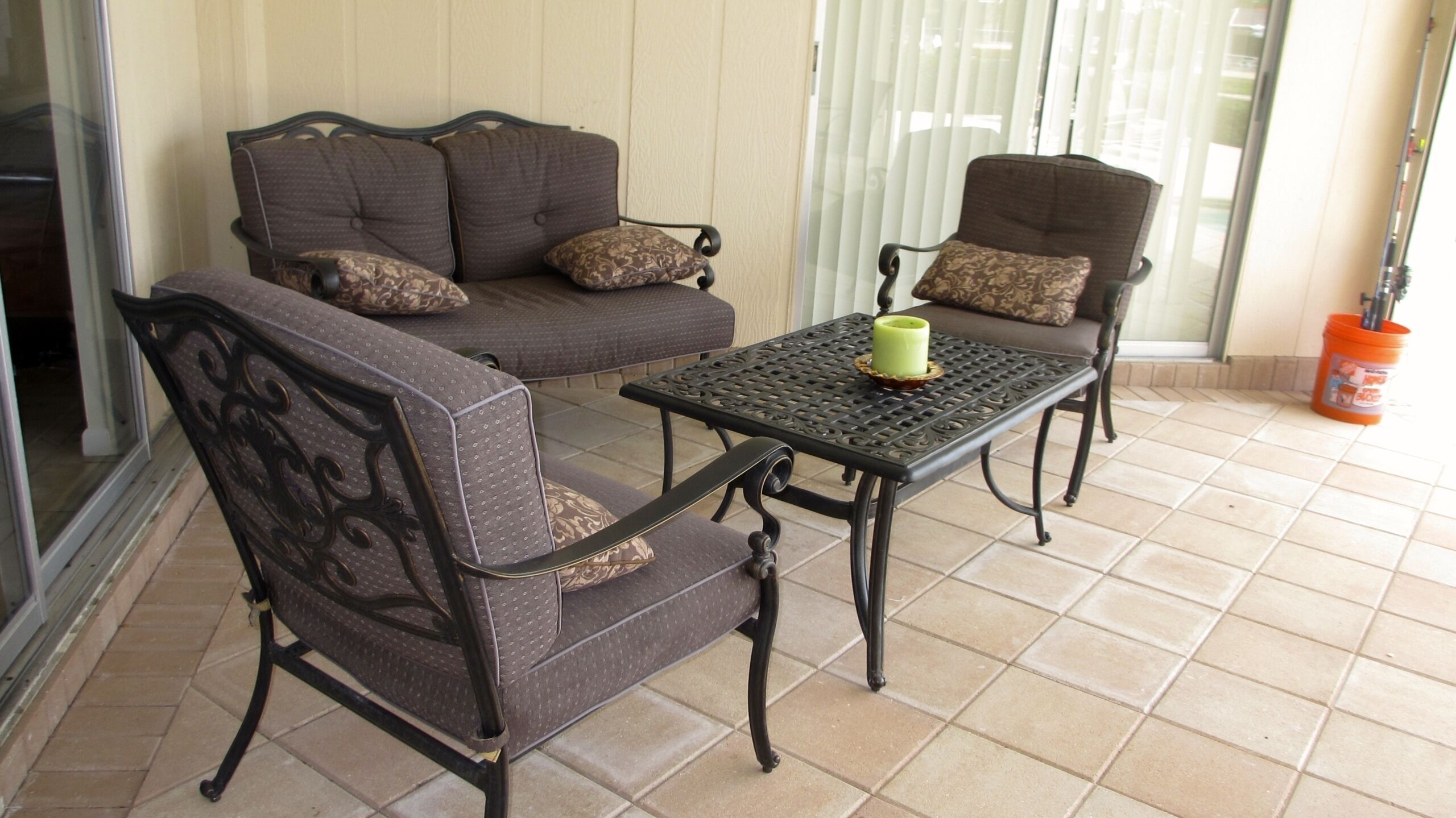 A patio area with a sofa set, a table, and a chair.