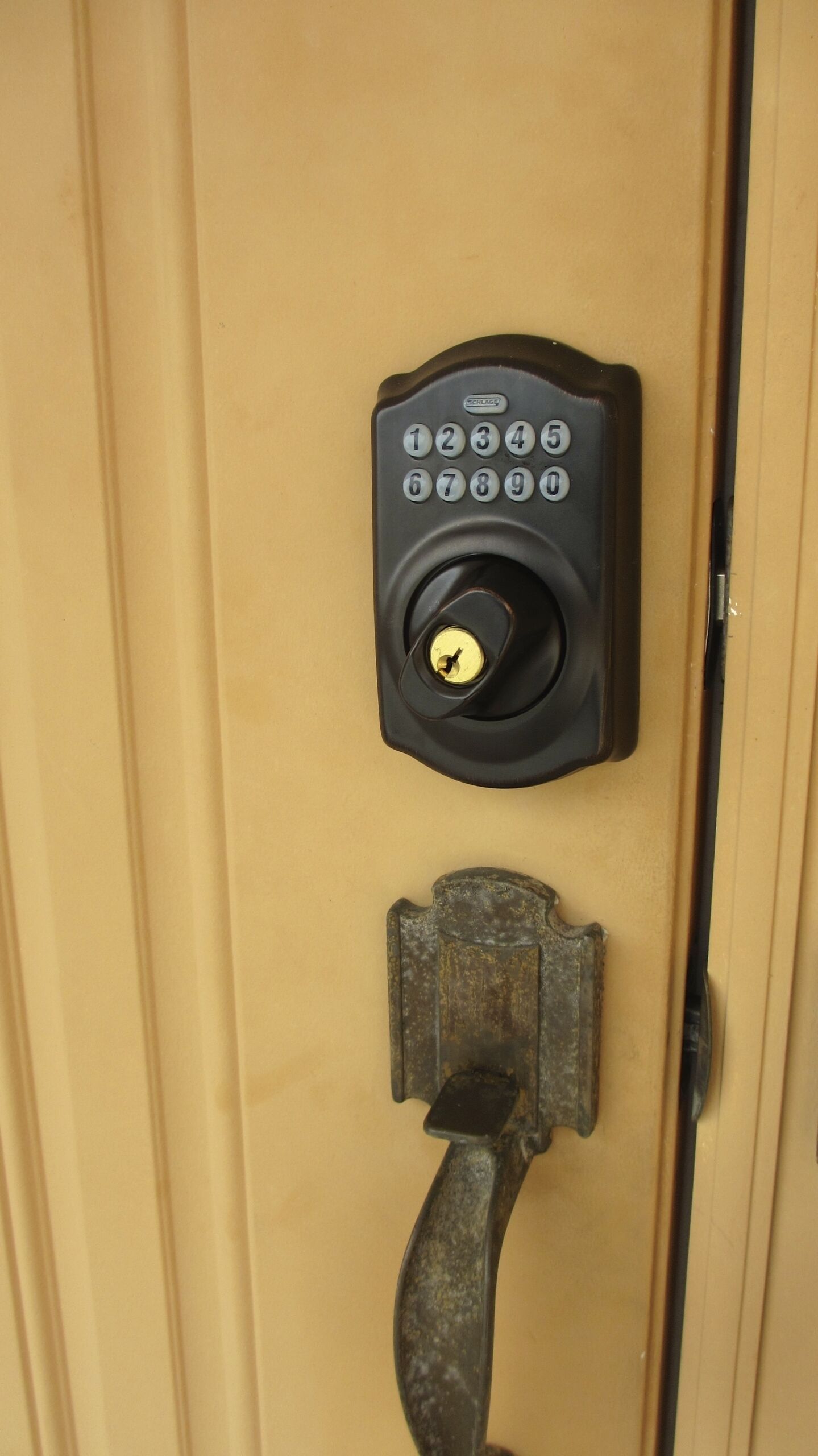 A door with a numeric keypad lock and a deadbolt.