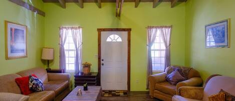 A cozy living room with two sofas, a coffee table, and a door with a window.