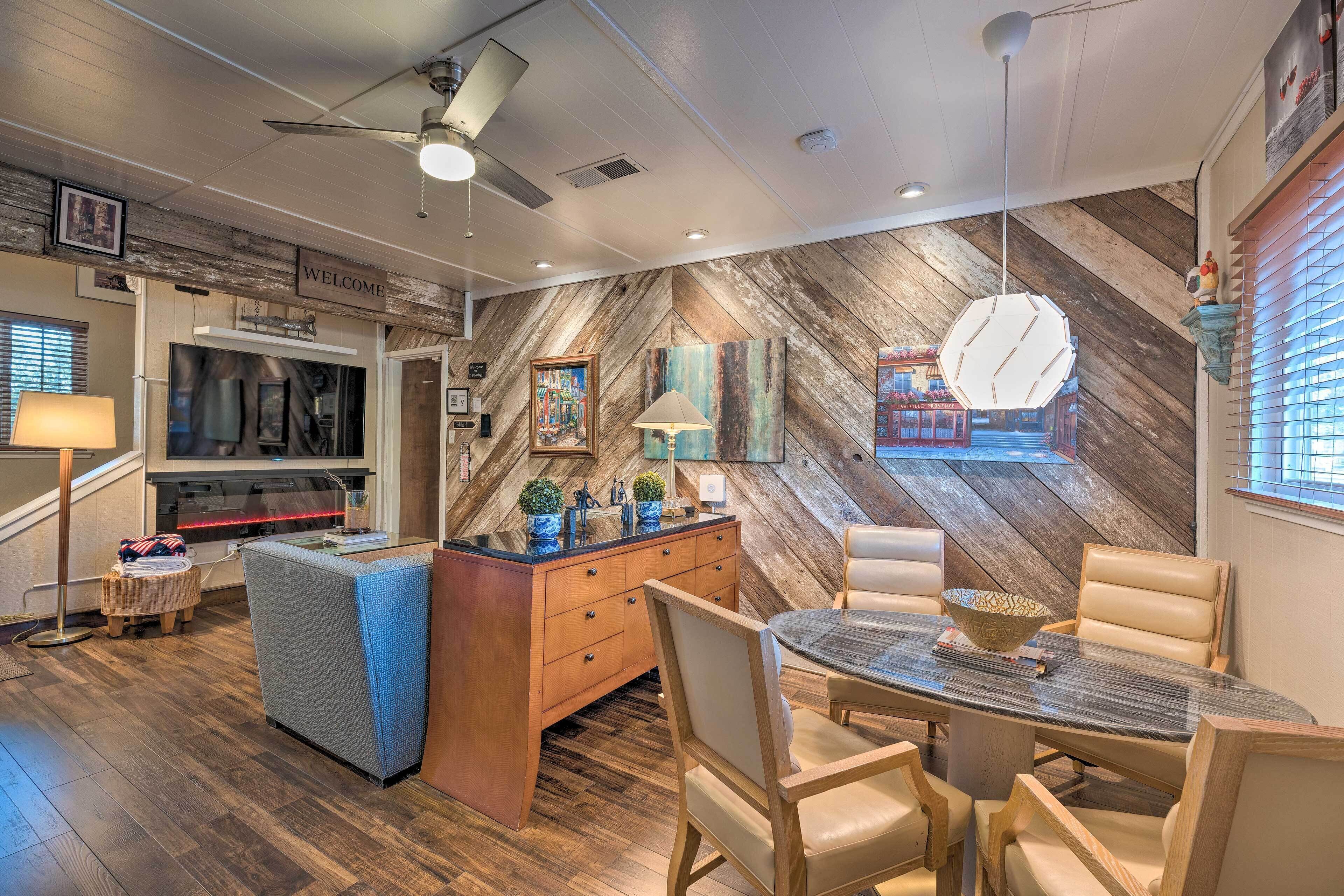 Une cuisine moderne avec un mur en bois disposé en motif chevron, un four encastré et un coin repas comprenant une table ronde et des chaises.