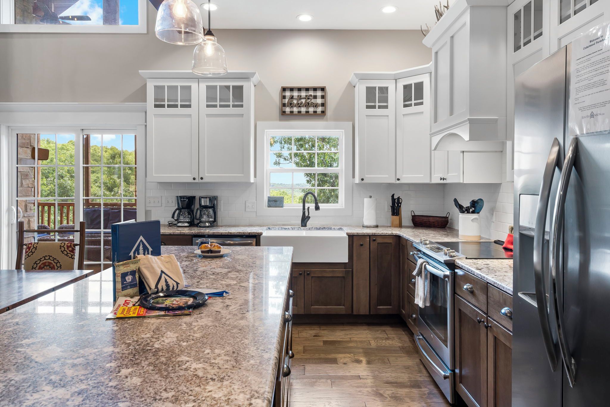 A modern kitchen with white cabinetry, a granite countertop, and a stainless steel refrigerator.