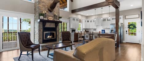 A spacious living room with a fireplace, a large sofa, and a dining area.