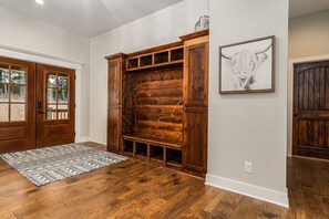 A wooden bench with a bench seat and a wall-mounted coat rack.