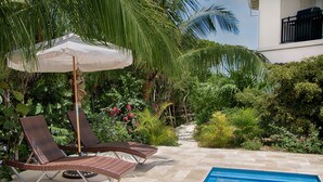 Un espace aménagé au bord de la piscine, avec des chaises longues et une piscine.