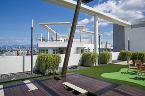 Enjoy the city skyline from our rooftop terrace with a clear view of high-rise buildings and a distant mountain.