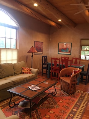 Uma sala de estar acolhedora com um sofá, uma mesa de centro e um tapete estampado.