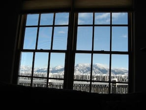 Uma grande janela com vista para montanhas nevadas e céu claro.