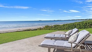 Una terrazza sulla spiaggia con poltrone relax e vista sull'oceano.