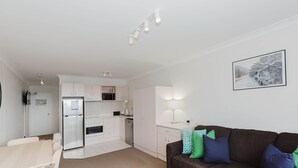 A modern apartment with a kitchen, dining area, and living room.