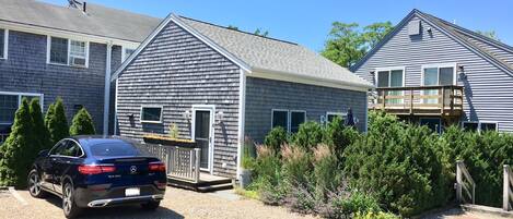 A two-story house with a gravel driveway and a parked car.