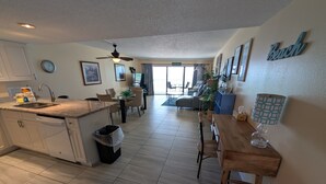 A modern kitchen with a dining area, a ceiling fan, and a view to the living room. - Chateaux Condominium 404-Breathtaking gulf views! (Indian Shores)