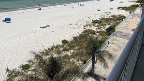 A beach with umbrellas, a clear sky, and a view of the ocean. - Chateaux Condominium 404-Breathtaking gulf views! (Indian Shores)
