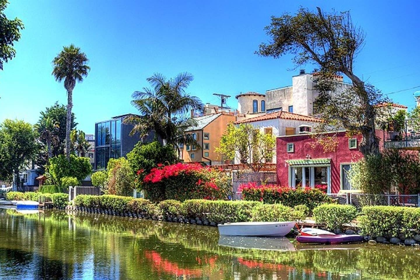 A waterfront property with a canal, boats, and lush greenery.
