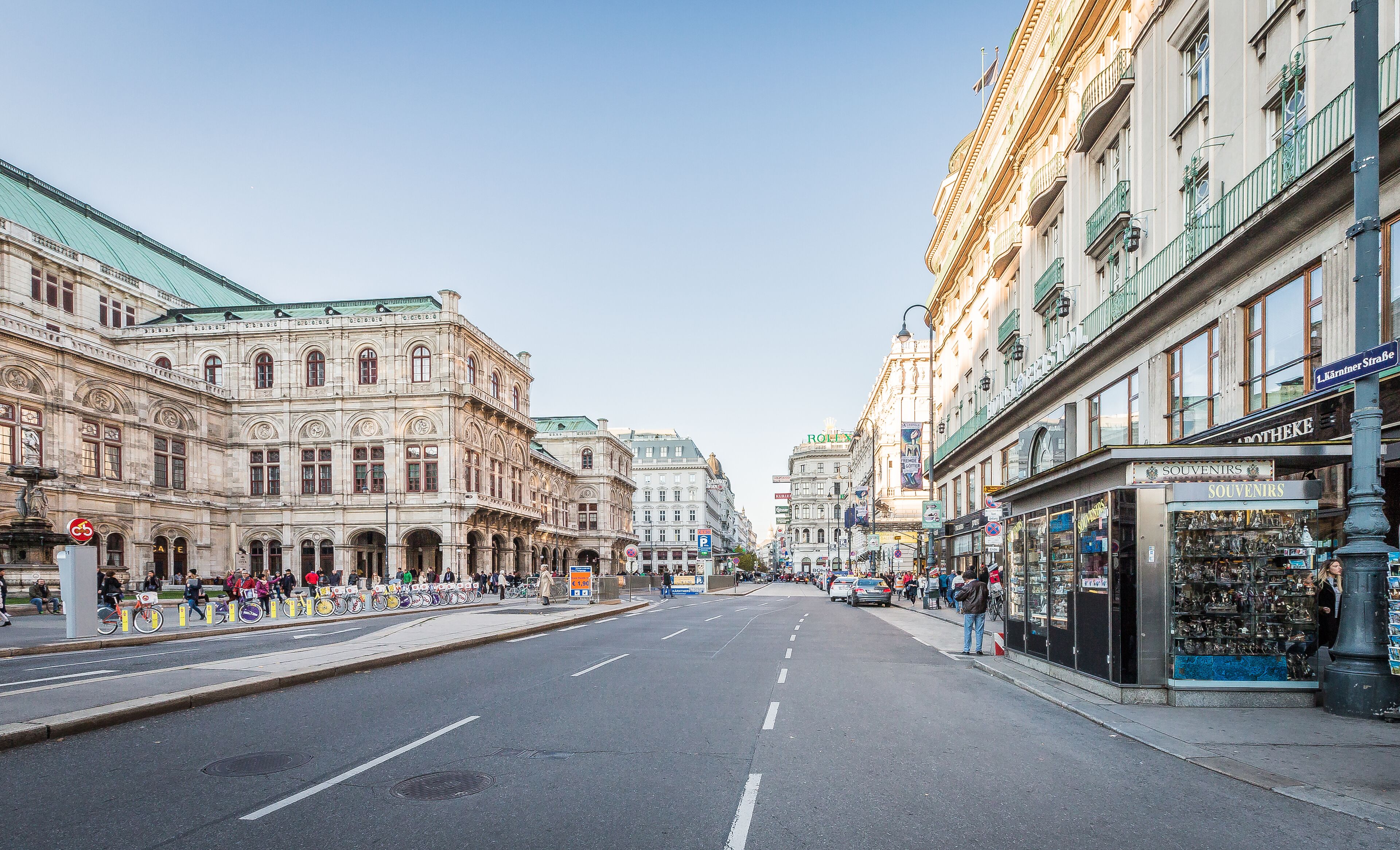 A street with historic buildings, a pharmacy, and a souvenir shop.