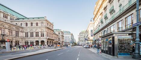 A street with historic buildings, a pharmacy, and a souvenir shop.