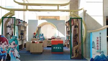 Una librería con una mesa de exhibición central, estanterías a ambos lados y un arco decorativo.