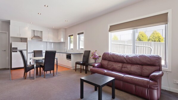 A modern apartment with a dining area, kitchen, and living room. - Stenmark - 5/3 Poley Cow Lane (Jindabyne)