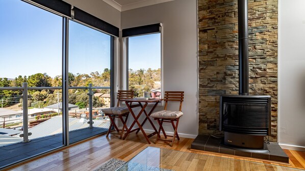 Enjoy a cozy stay with a fireplace and outdoor balcony offering a view of the surrounding landscape.