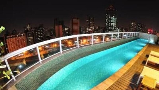 A rooftop pool with a city skyline view at night. - 100m from the Avenue. Paulista / 30m from the shopping mall / close to the subway and hospitals (Bela Vista)