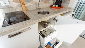 A kitchen with a granite countertop, stainless steel sink, and a built-in drawer with utensils. - 100m from the Avenue. Paulista / 30m from the shopping mall / close to the subway and hospitals (Bela Vista)