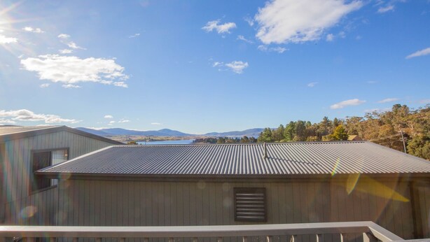 A building with a metal roof overlooking a lake and mountains. - Boronia - 5/30 Nettin Circuit (Jindabyne)