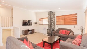 A living room with a fireplace, a television, and a sofa set. - Boronia - 5/30 Nettin Circuit (Jindabyne)