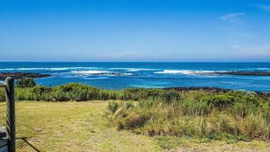 A coastal view with a grassy foreground, rocky shoreline, and the ocean. - Wytonia 1 - Spectacular Ocean Views (Port Fairy)