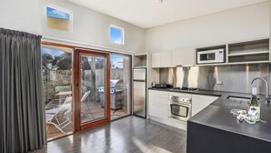 A modern kitchen with a built-in oven, microwave, and gas stove. - Hearns Beachside Villa 3 (Port Fairy)