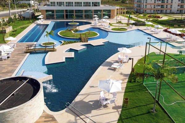 Una piscina al aire libre, sombrillas, sillones reclinables de piscina