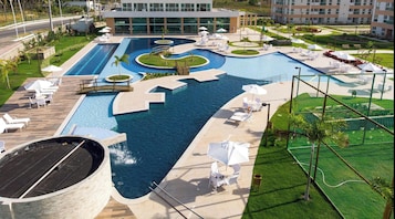 Una piscina al aire libre, sombrillas, sillones reclinables de piscina