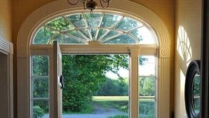 A doorway with a glass door leading to a lawn, a chandelier, and a doormat. - Country home 5 bdrs, 6 baths, yoga/art studio, large garden near wineries +beach (Consecon)