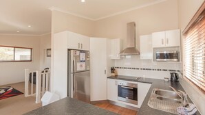 Una cocina moderna con horno integrado, microondas y refrigerador de acero inoxidable.